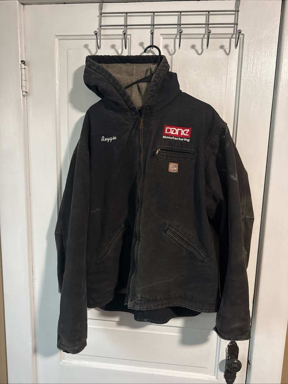 Distressed Carhartt Detroit Black Hooded Work Coat with โReggieโ name plate.